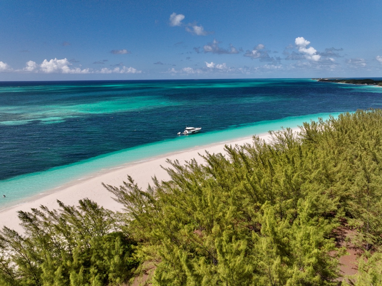 Aerial view of a boat anchored off a Bahamian cay